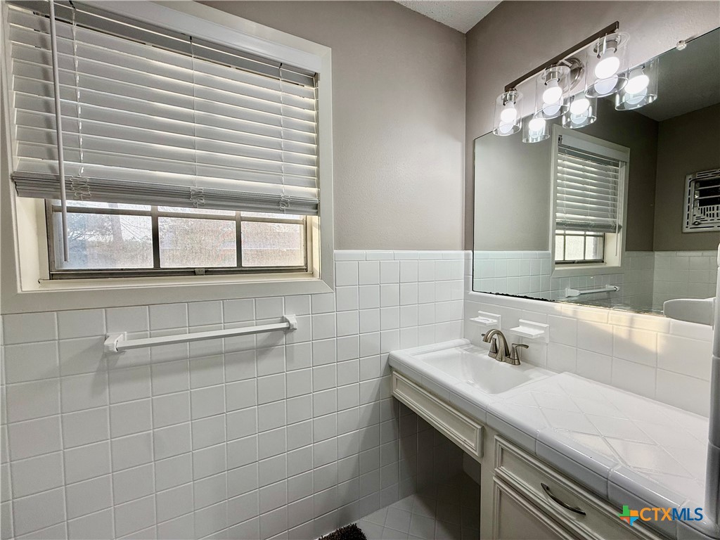 2407 East Airline Road Victoria, TX 77901 - Photo 31 of 38 a bathroom with a sink a large mirror and a window