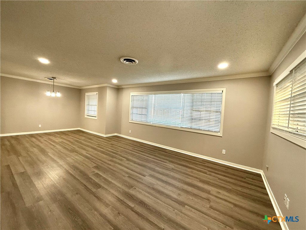 2407 East Airline Road Victoria, TX 77901 - Photo 4 of 38 a view of an empty room with wooden floor and a window
