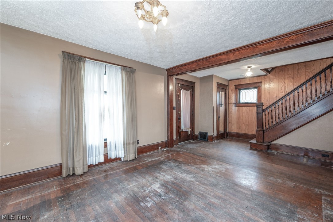 267 West Riddle Avenue Ravenna, OH 44266 - Photo 4 of 47 Ornate chandelier, wood-finish flooring, wood-paneled walls, wood staircase, and wood door frames
