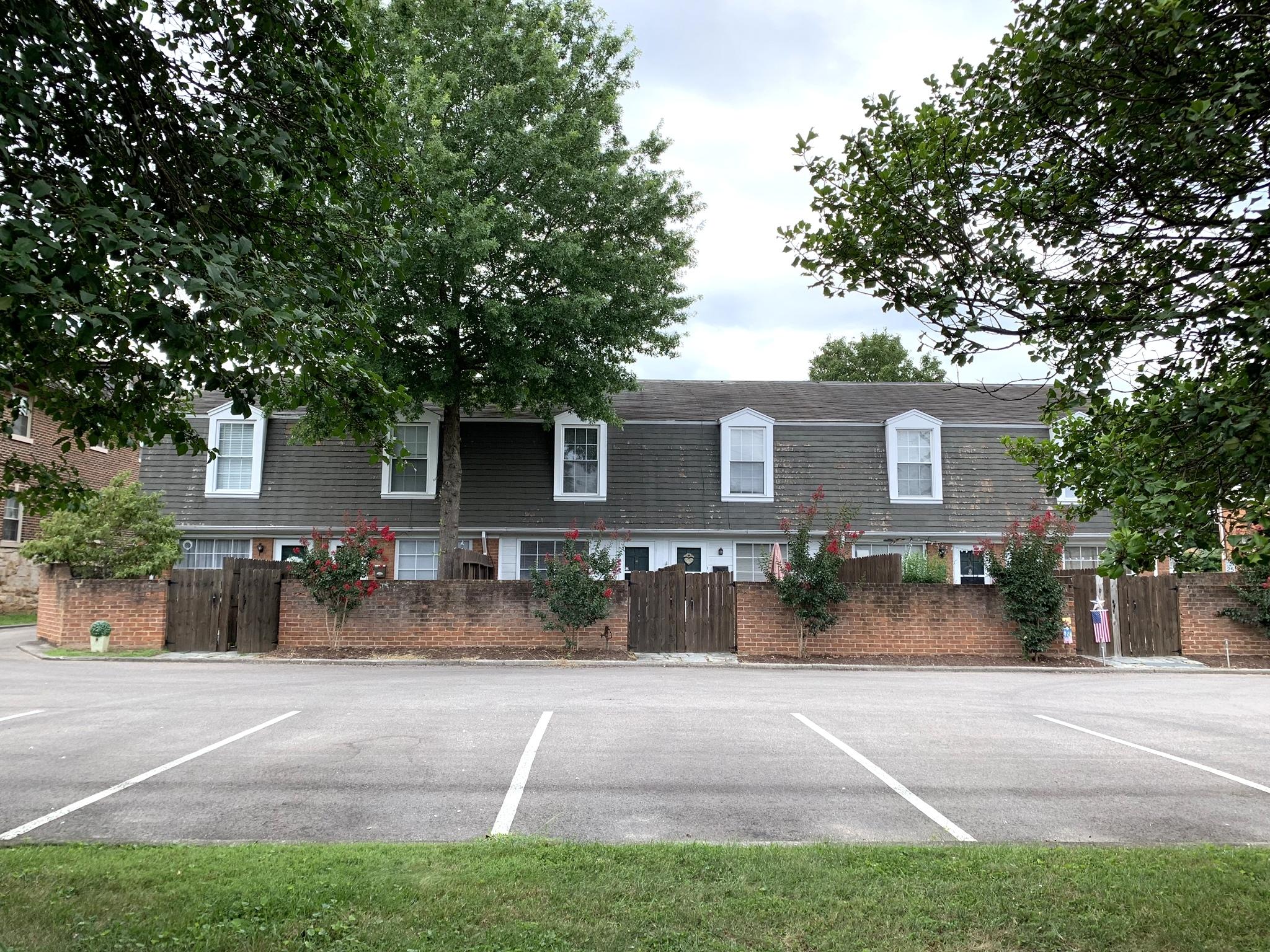 a view of a house with a yard and large tree
