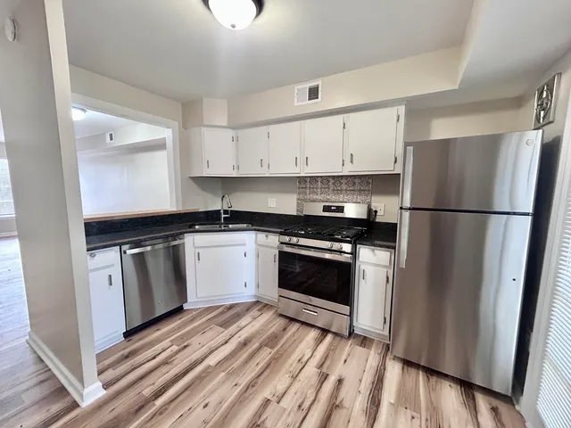 a kitchen with a refrigerator stove and white cabinets