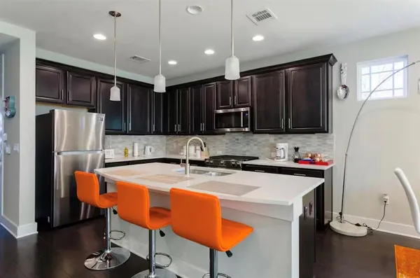 a kitchen with stainless steel appliances granite countertop a sink refrigerator and a stove