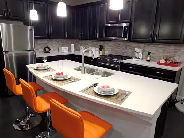 a kitchen with a sink a stove and chairs