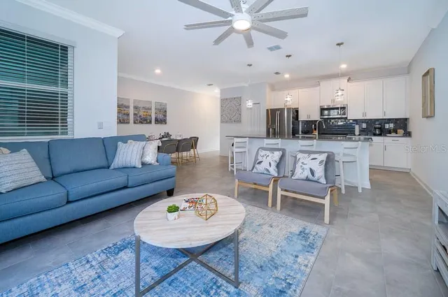 a living room with furniture a rug and kitchen view