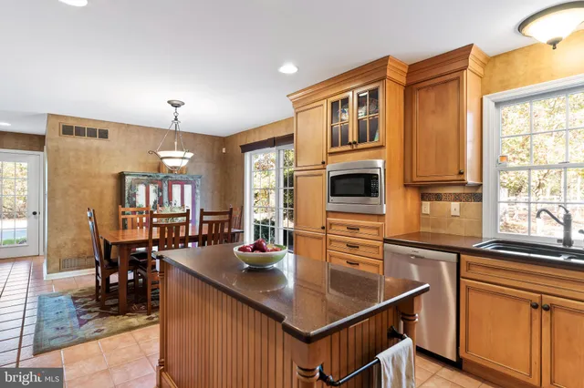 a dining room with furniture a chandelier a rug and a window