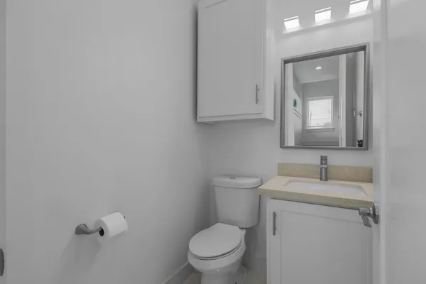 a bathroom with a granite countertop sink a toilet and shower