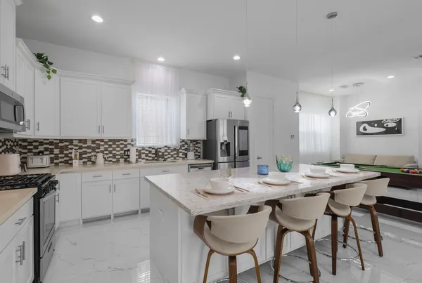 a kitchen with stainless steel appliances kitchen island granite countertop a sink and cabinets