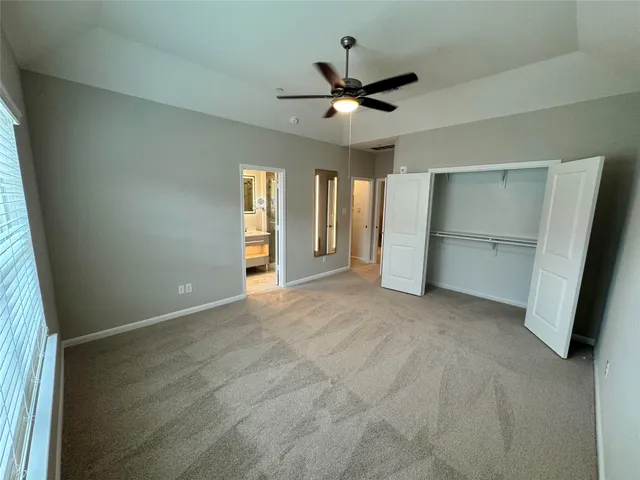 an empty room with closet and windows