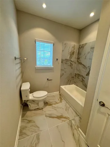 a bathroom with a toilet and a bathtub