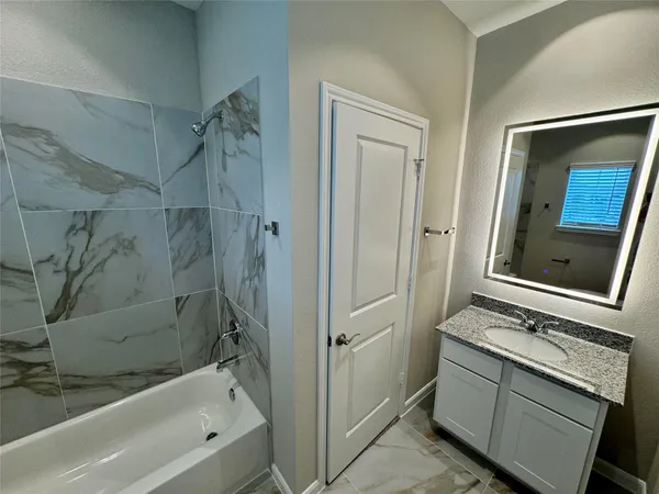 a bathroom with a granite countertop sink mirror and shower