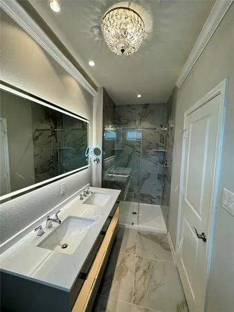 a bathroom with a sink a large mirror and shower