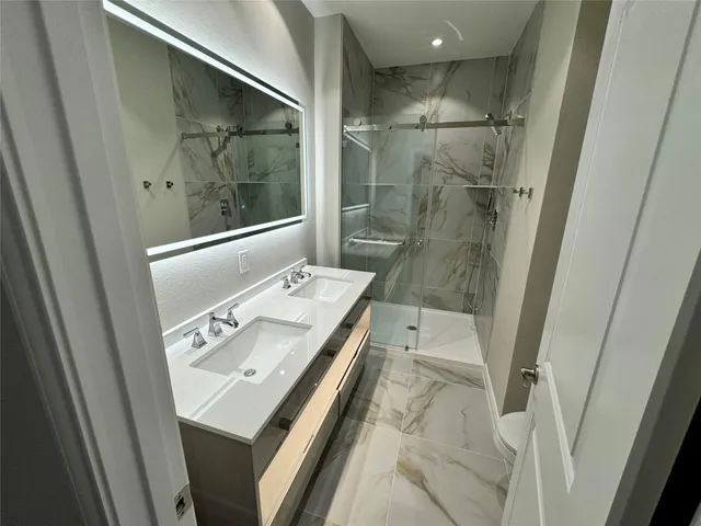 a bathroom with a sink a mirror and a shower