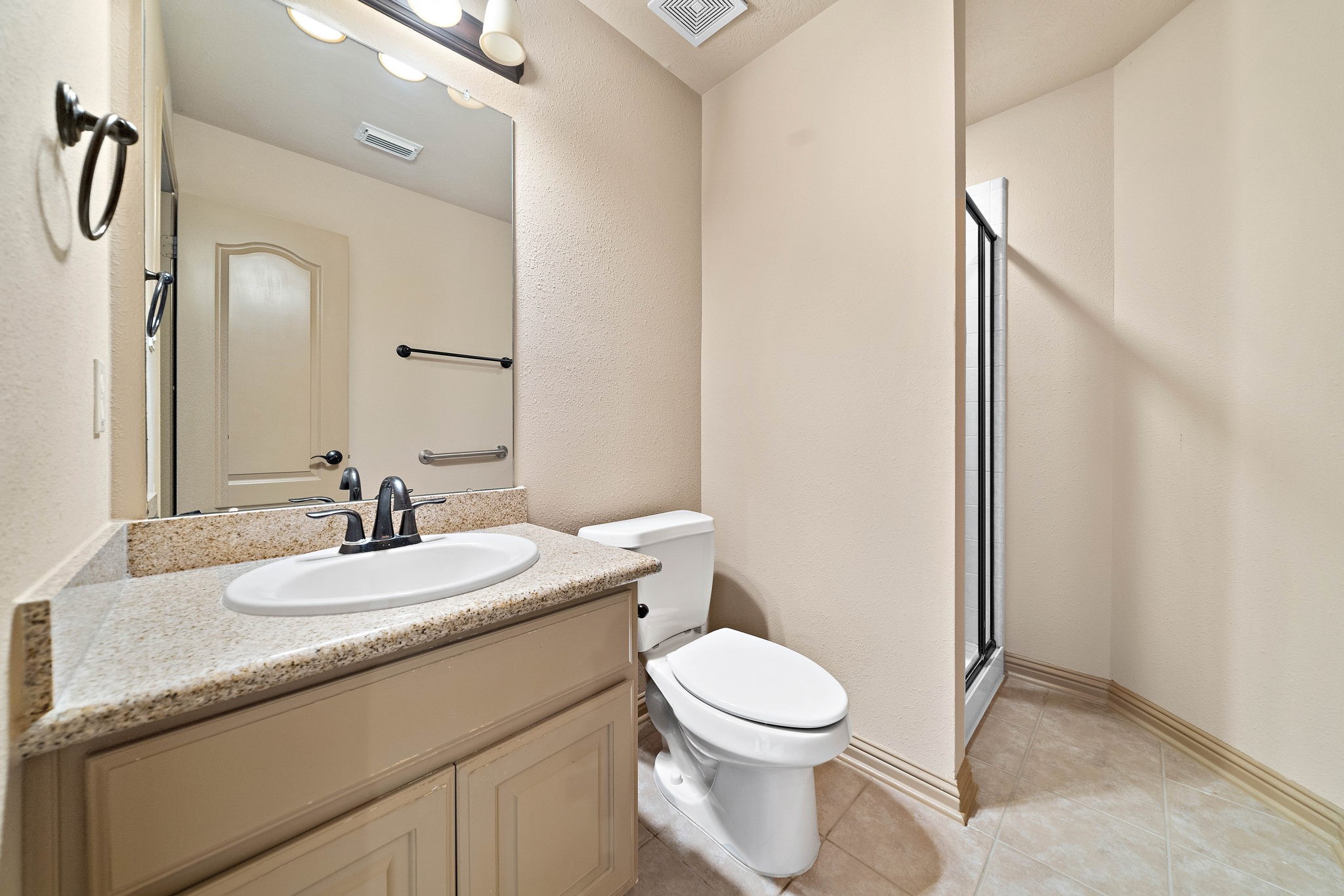 10015 Cinco Ridge Drive Katy, TX 77494 - Photo 12 of 17 a bathroom with a granite countertop sink a toilet and a mirror