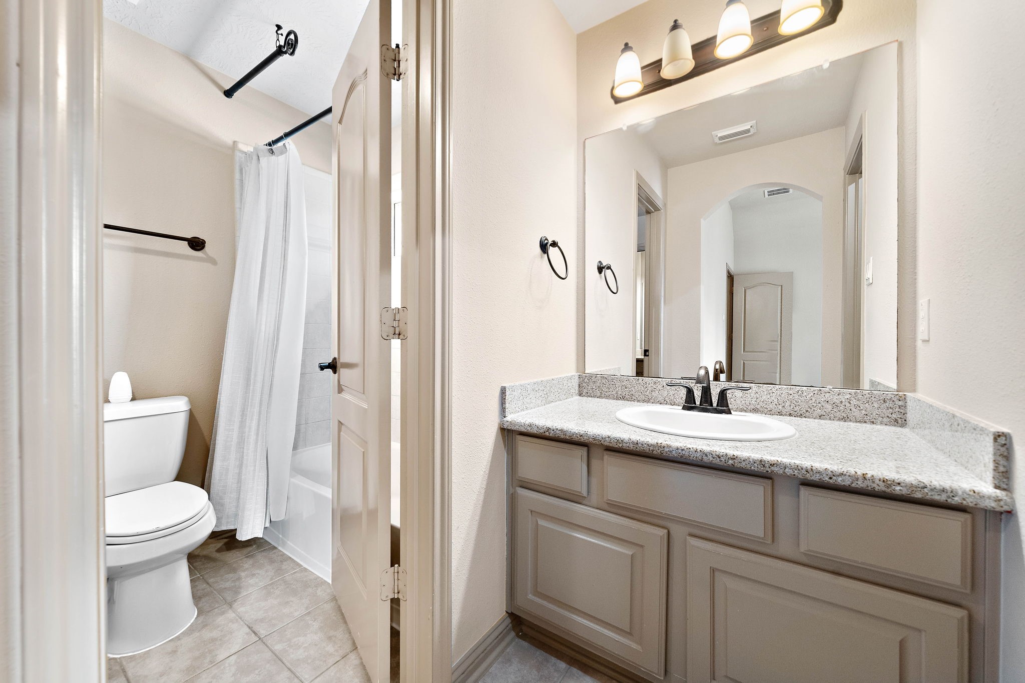 10015 Cinco Ridge Drive Katy, TX 77494 - Photo 15 of 17 a bathroom with a granite countertop sink toilet and shower