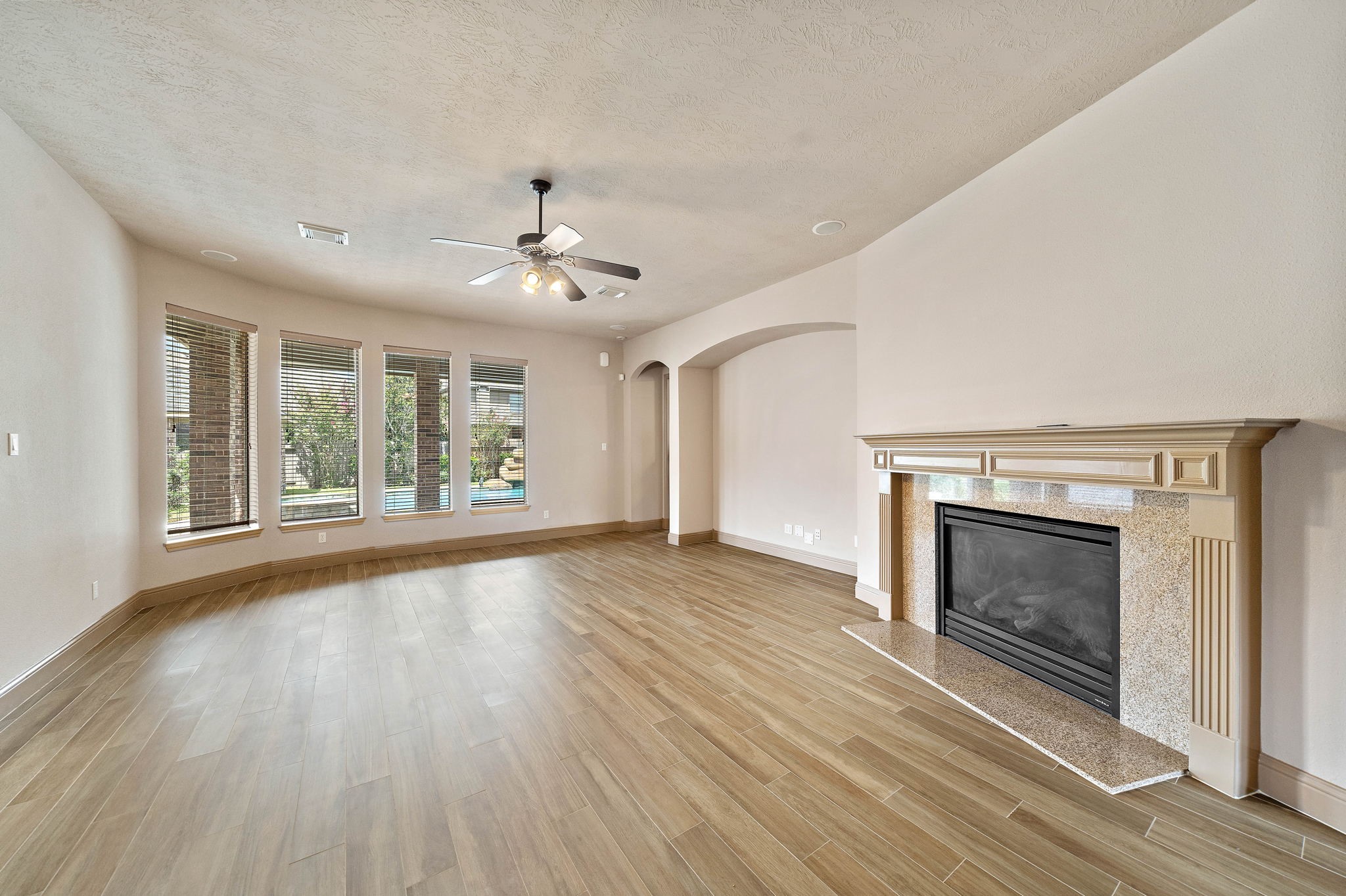 10015 Cinco Ridge Drive Katy, TX 77494 - Photo 5 of 17 a view of an empty room with wooden floor fireplace and a window