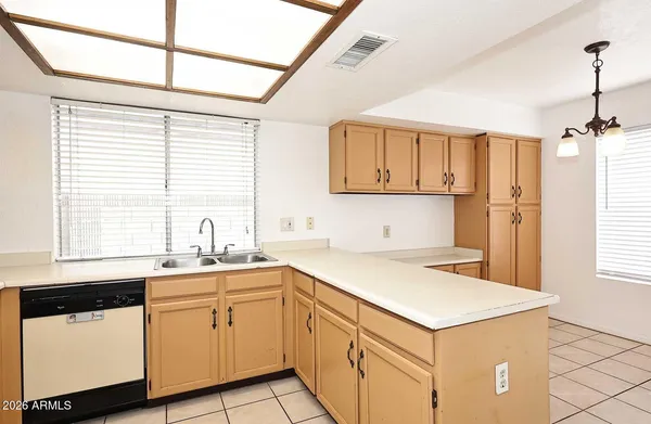 a kitchen with white cabinets and window