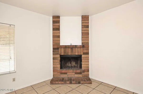 a view of an empty room with window and fireplace