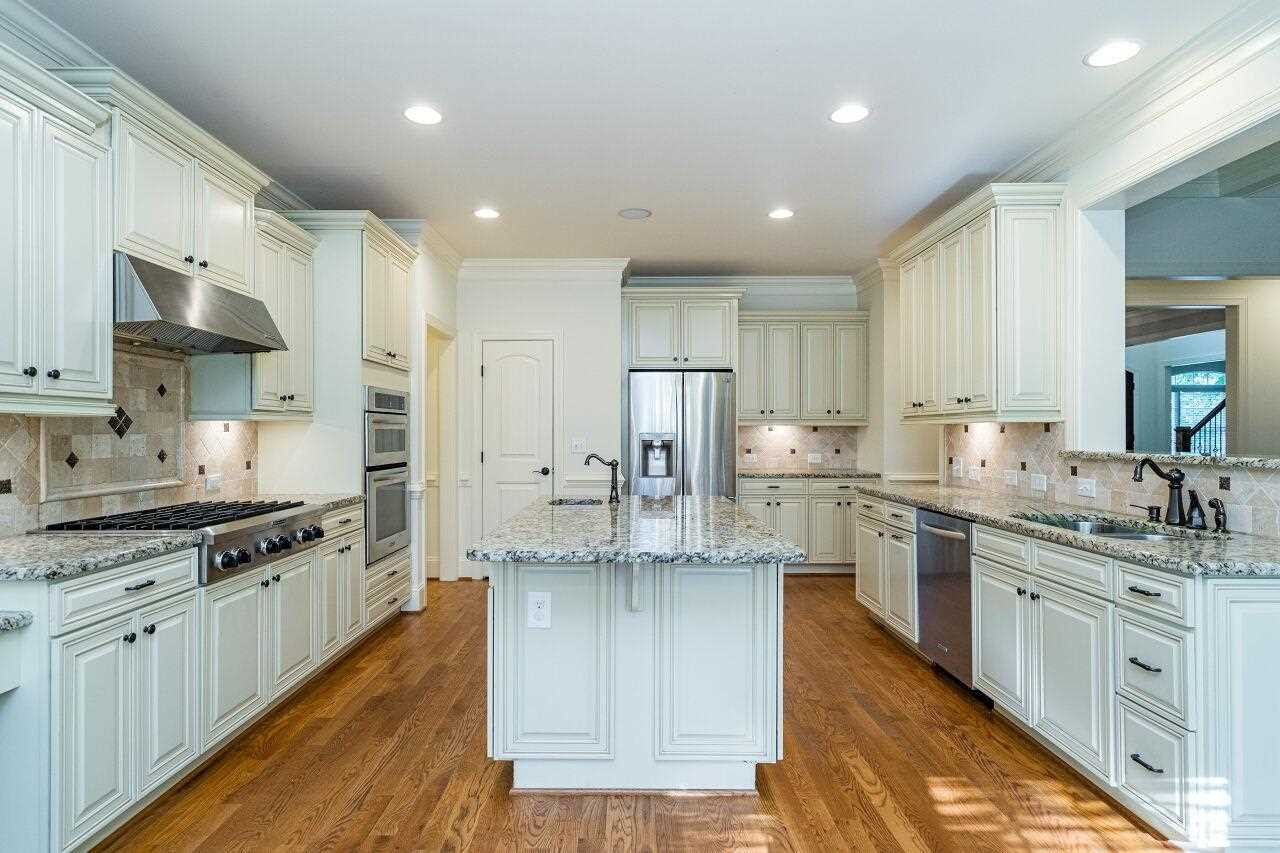 3820 Laurel Hills Road Raleigh, NC 27612 - Photo 11 of 30 Gourmet kitchen features upgraded cabinets, granite, refrigerator, gas range, double ovens, prep sink and oversized island! Kitchen