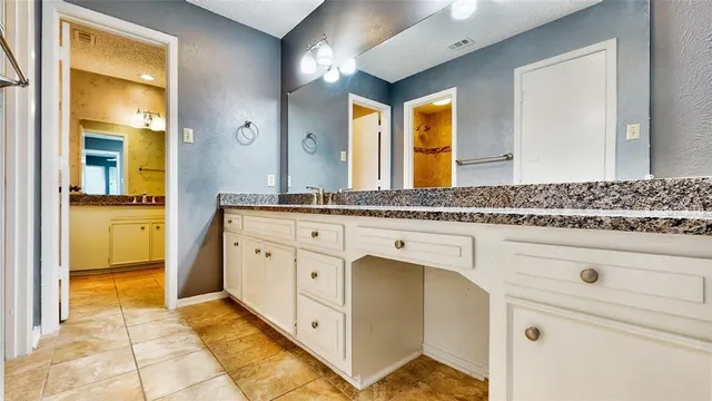 a spacious bathroom with a granite countertop sink and a mirror