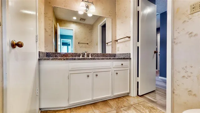 a bathroom with a granite countertop sink and a mirror