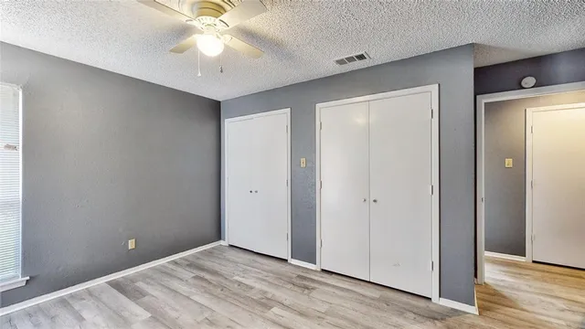 an empty room with closet and a chandelier fan