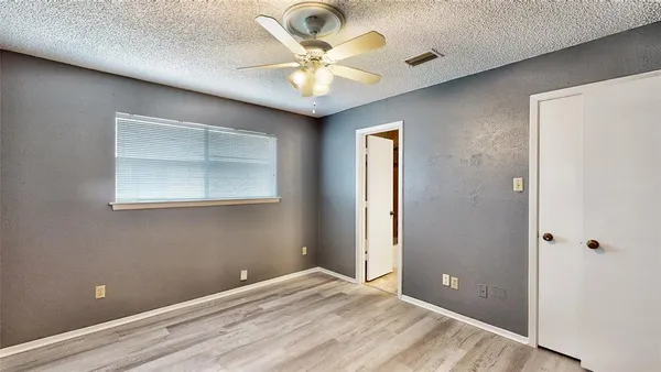 an empty room with fan and windows