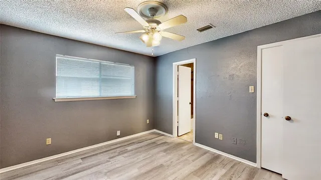 an empty room with fan and windows