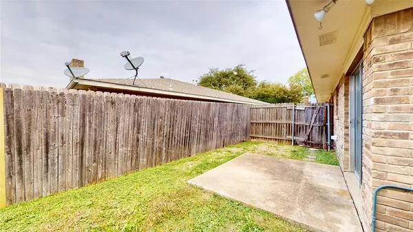 a backyard of a house with plants and wooden fence