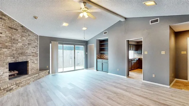a view of a livingroom with wooden floor and a fireplace