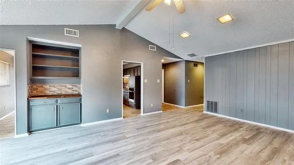 a view of empty room with wooden floor and entryway