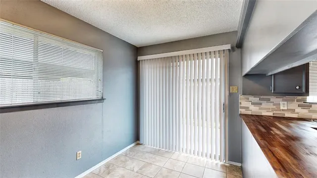 a view of a kitchen with an empty room and wooden floor