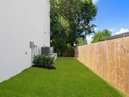 a view of a backyard with potted plants and large tree