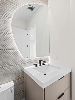 a bathroom with a sink a toilet and a mirror