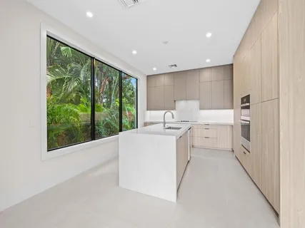 a large white kitchen with a large window