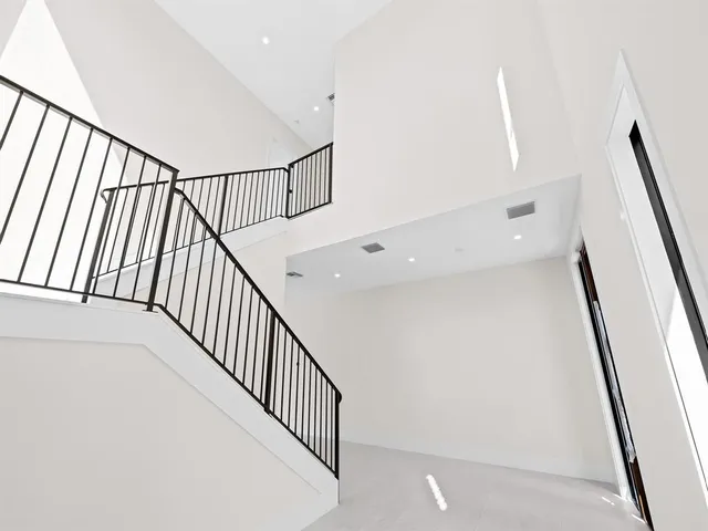 a view of staircase with railing and white walls