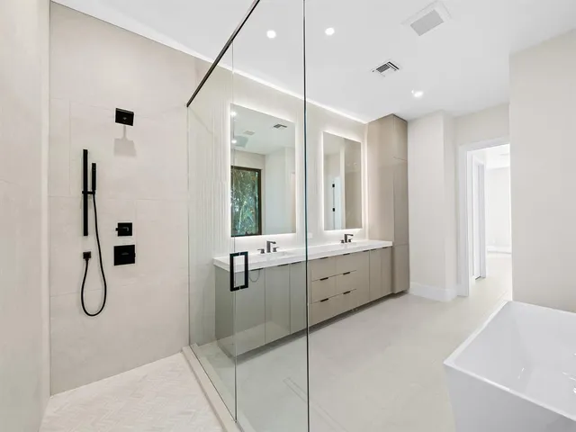a bathroom with a double vanity sink a mirror and a shower