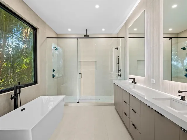 a bathroom with a double vanity sink mirror double and shower