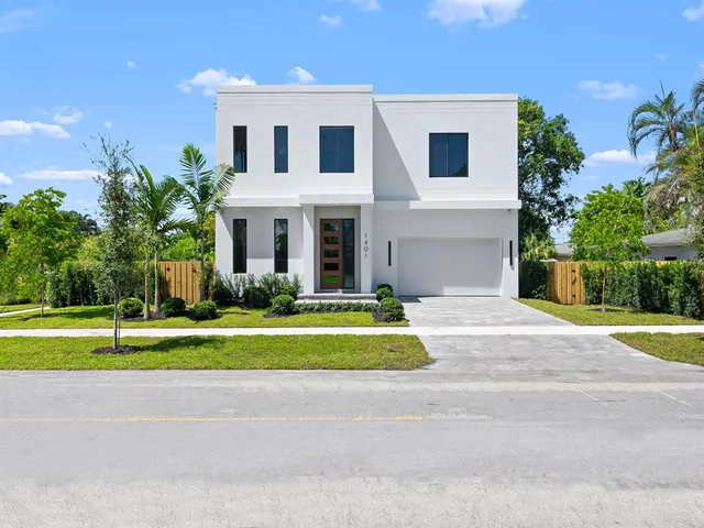 a front view of a house with a yard and trees