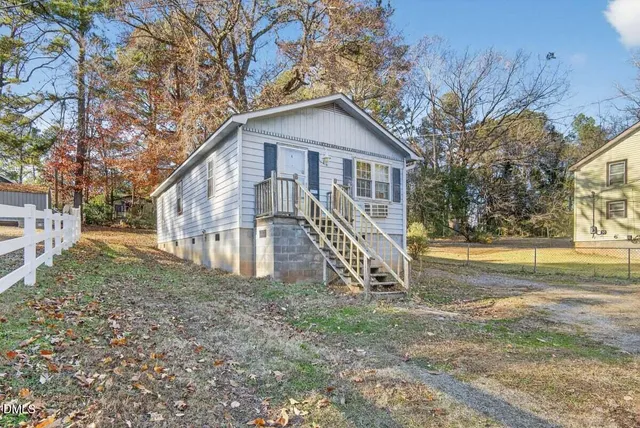 a view of a house with backyard and trees