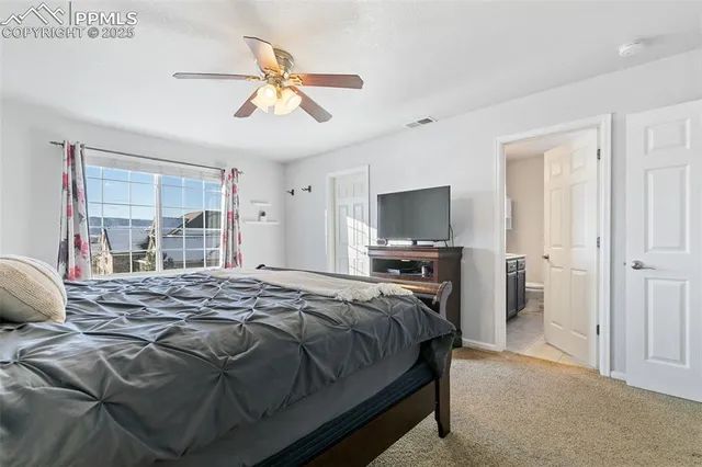 a bedroom with a bed and a flat tv screen on dresser