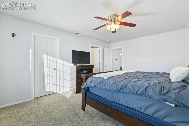 a bedroom with a bed and a flat tv screen on dresser