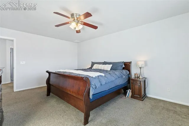 a bedroom with a bed and a ceiling fan
