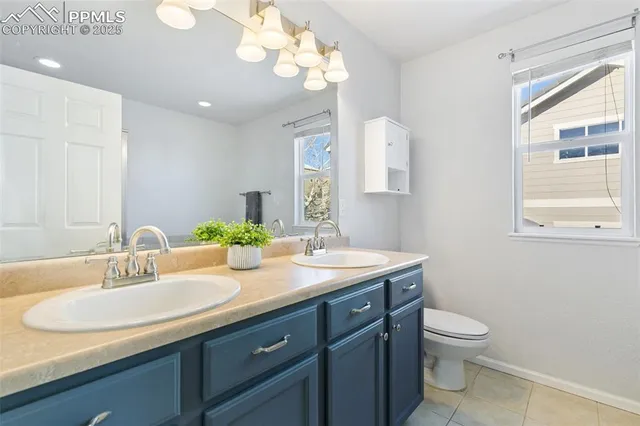 a bathroom with a granite countertop sink a toilet and a mirror