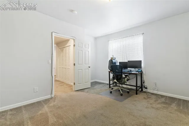 a view of a workspace with furniture and a window