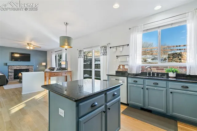 a kitchen with granite countertop a sink counter top space appliances and cabinets