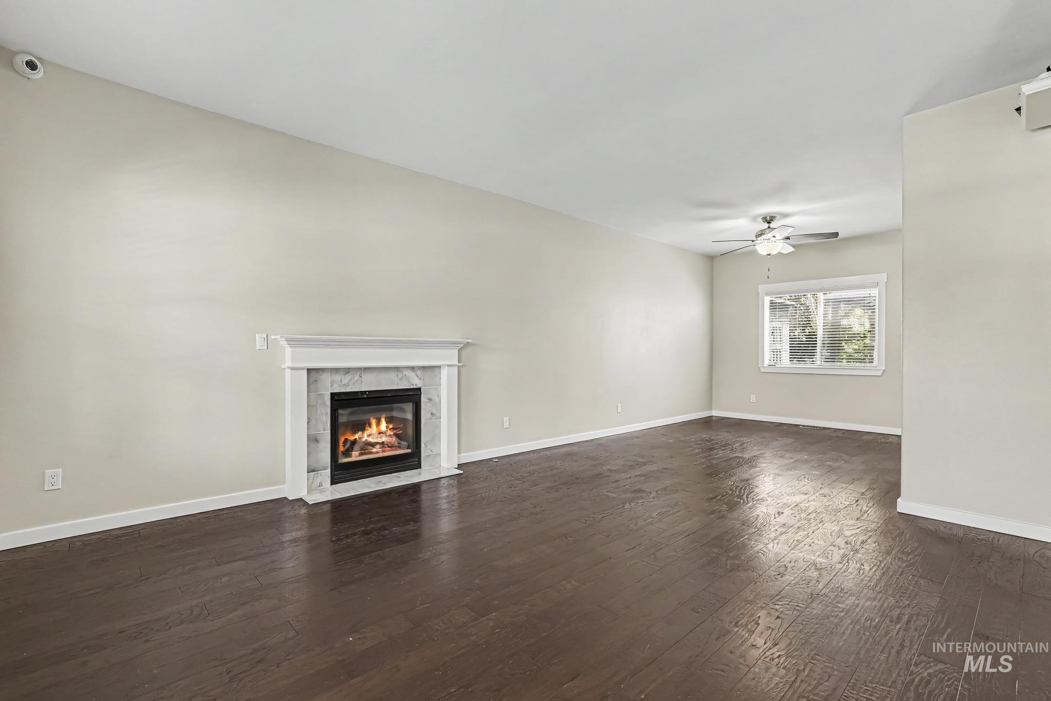 14421 West Stockwell Street Boise, ID 83713 - Photo 6 of 20 Spacious room with a fireplace featuring a white mantel and marble-style surround