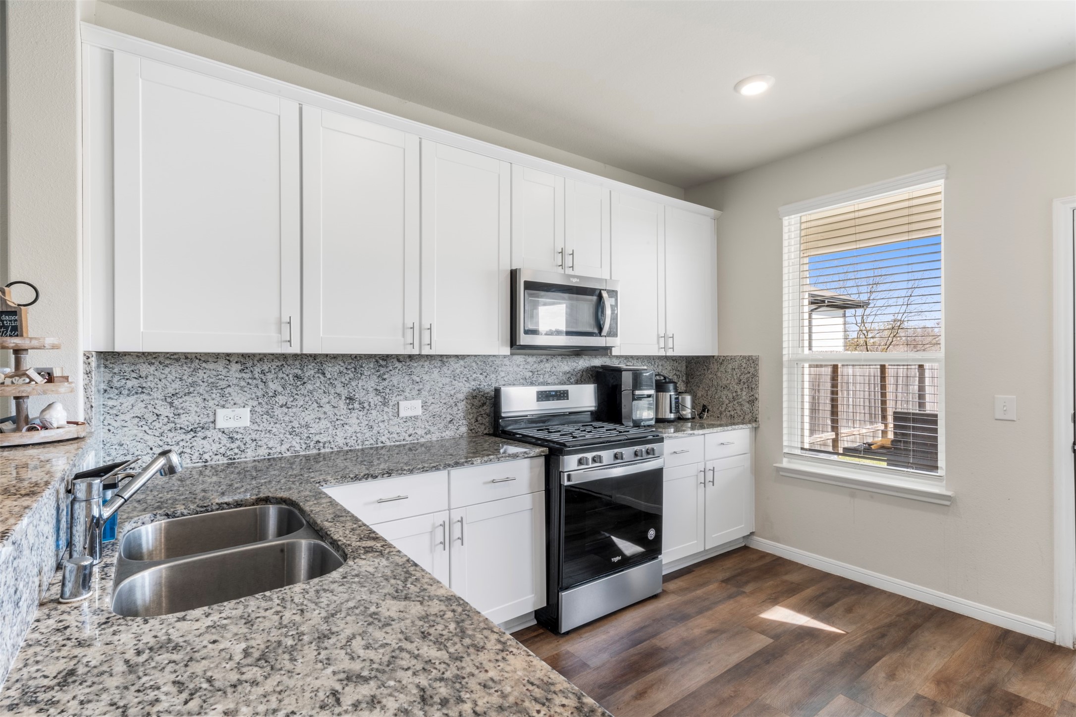 4611 Prairie Chase Drive Houston, TX 77069 - Photo 11 of 44 a kitchen with granite countertop a sink wooden floor and a stove top oven