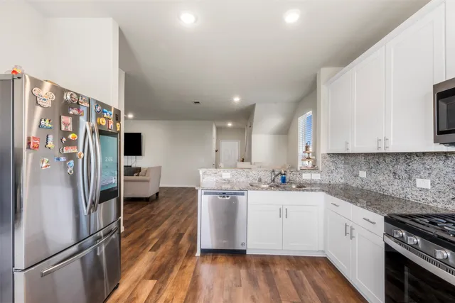 a kitchen with stainless steel appliances a refrigerator sink and microwave