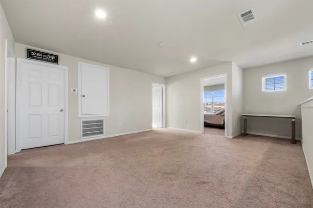 an empty room with a cabinet and mirrors