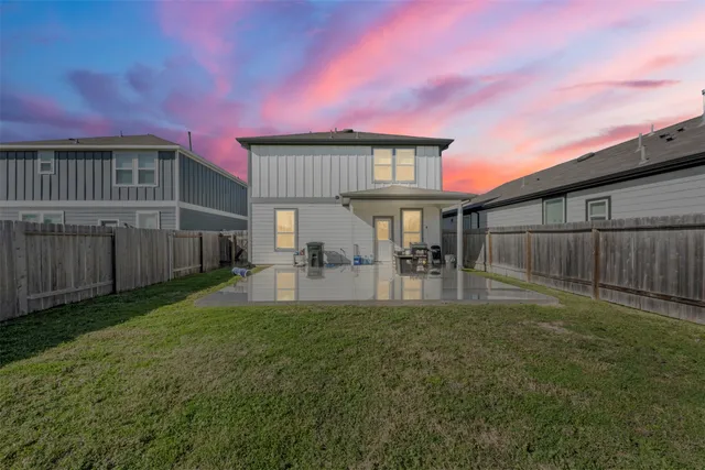 a view of backyard of house with wooden deck and furniture